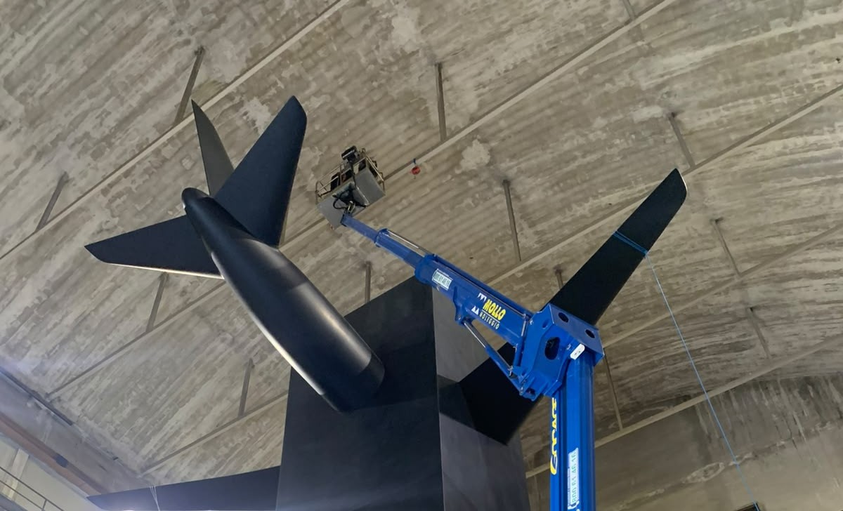 Sollevamento di una scultura nera con un aereo incorporato